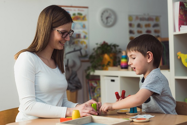 Teacher and child playing with didactic colorful toys indoors – preschool İstanbul Psikolog